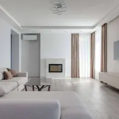 Nowoczesny salon z kanapą, kominkiem i telewizorem.