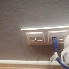 Gniazdo antenowe i sieciowe z podłączonym niebieskim kablem.