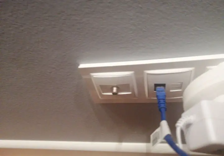 Gniazdo antenowe i sieciowe z podłączonym niebieskim kablem.