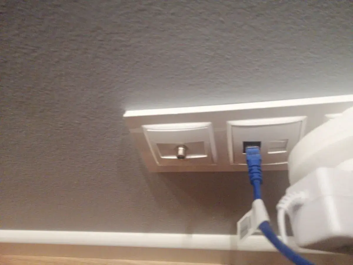 Gniazdo antenowe i sieciowe z podłączonym niebieskim kablem.